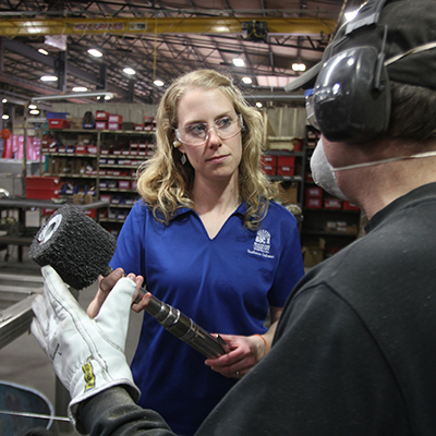 Beaver Dam Community HealthWORKS employee talking with a factory worker